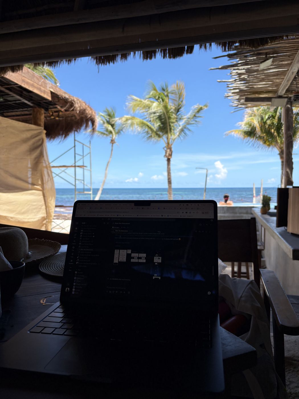 Laptop set up beachside with palm trees and the ocean in the background, Mexico