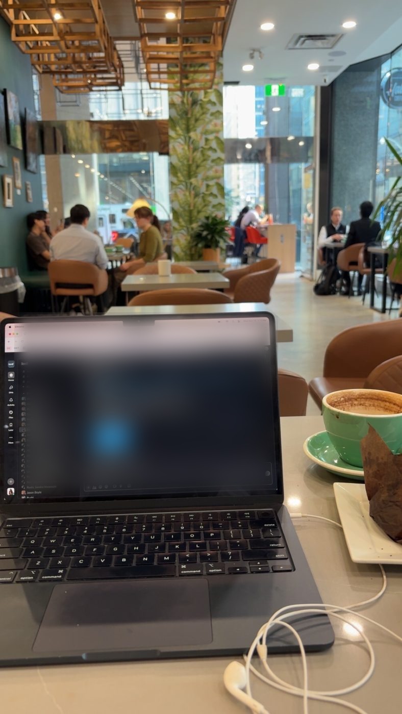 Kaviya working remotely on a laptop at a café